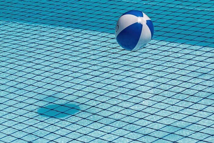  beach ball sitting on pool net