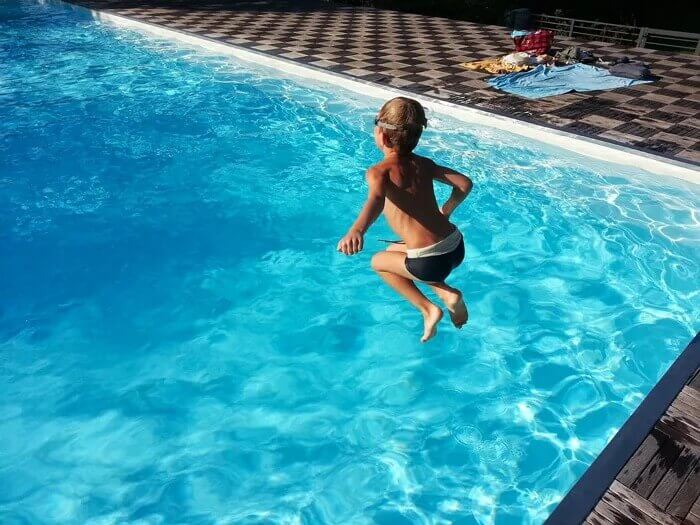 boy jumping in pool