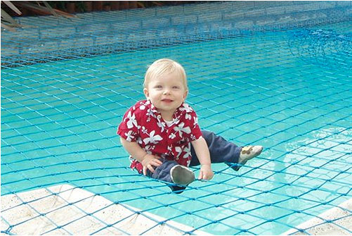 toddler sitting on pool net over water