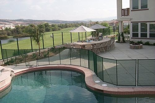 irregular shaped pool with removable mesh fencing installed