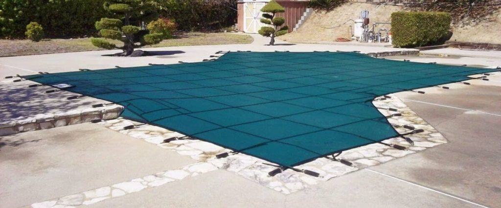 irregular shaped swimming pool with winter pool cover installed
