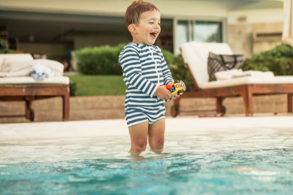 toddler in pool with a toy