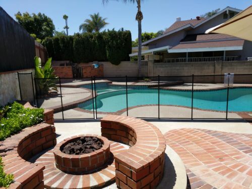 black mesh pool fence installed on irregular shaped backyard pool