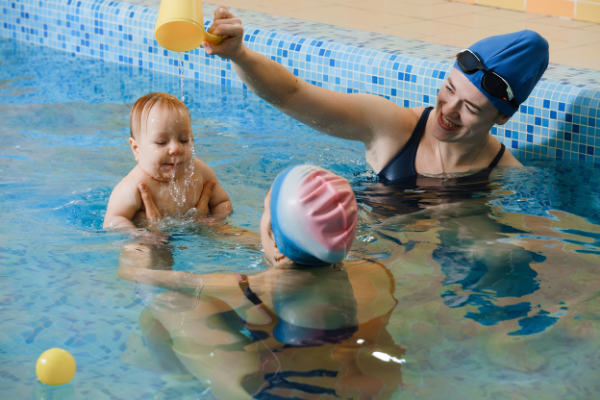 two swim instructors with a baby in a pool