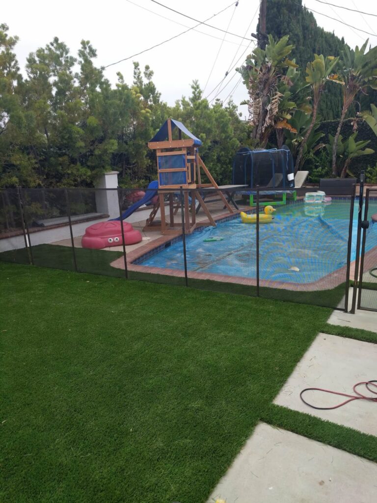 black mesh pool safety fence around a pool and playset