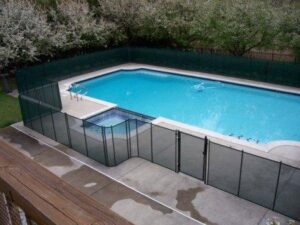 black removable mesh pool fence surrounding a pool and hot tub