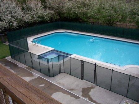 black removable mesh pool fence surrounding a pool and hot tub