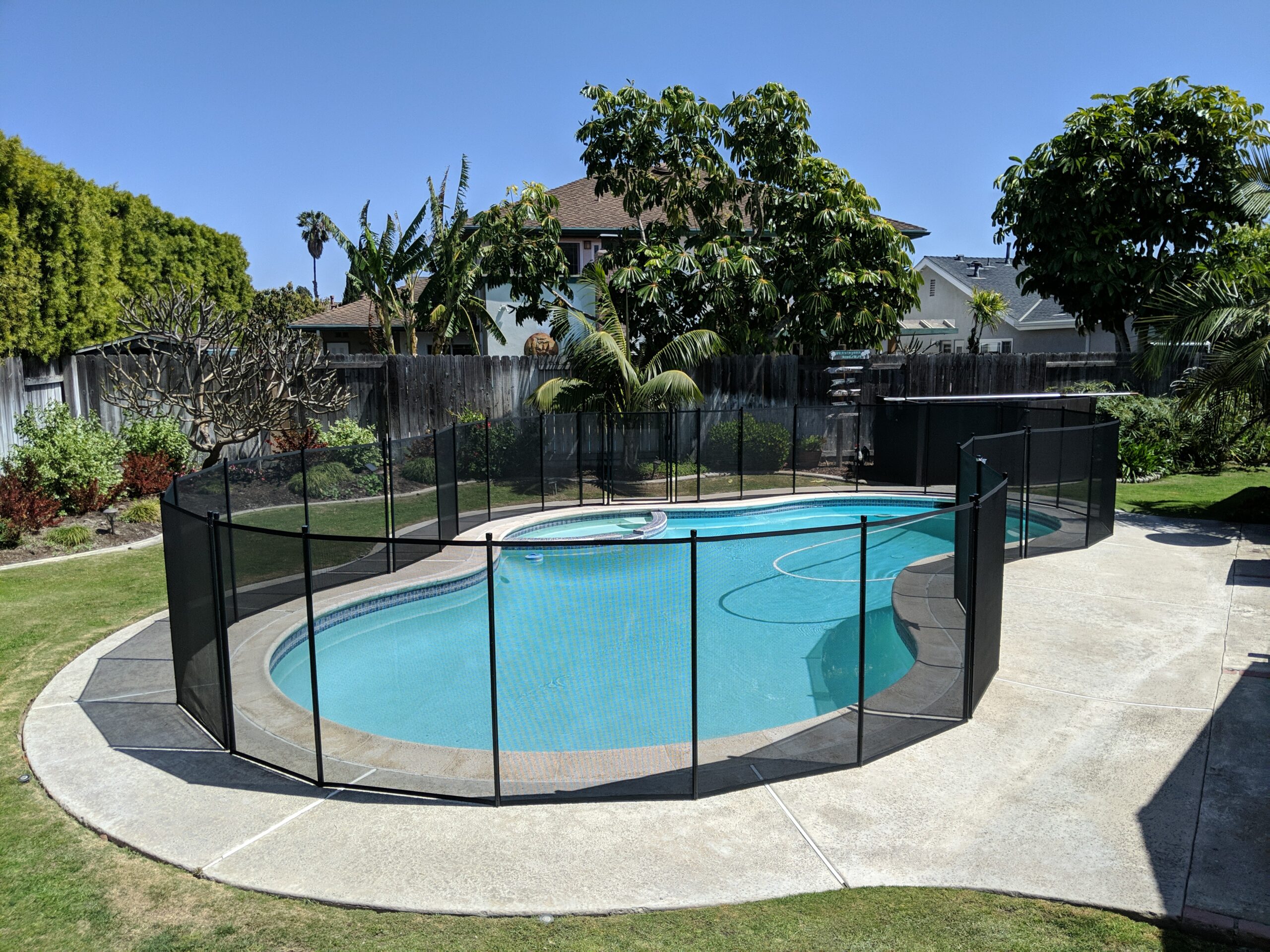 Black pool fence installed on an irregular shaped pool