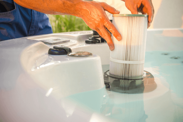 man performing hot tub maintenance and checking filters