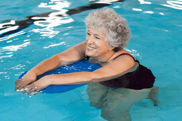 Senior woman floating on a flotation device in a pool