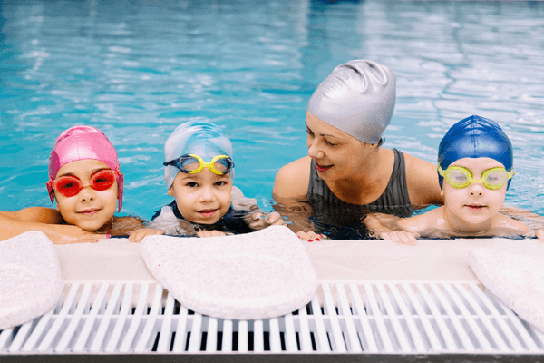 Kids in the pool with their swim instructor