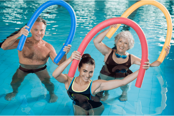 elderly couple and instructor using pool floats for aquatic therapy