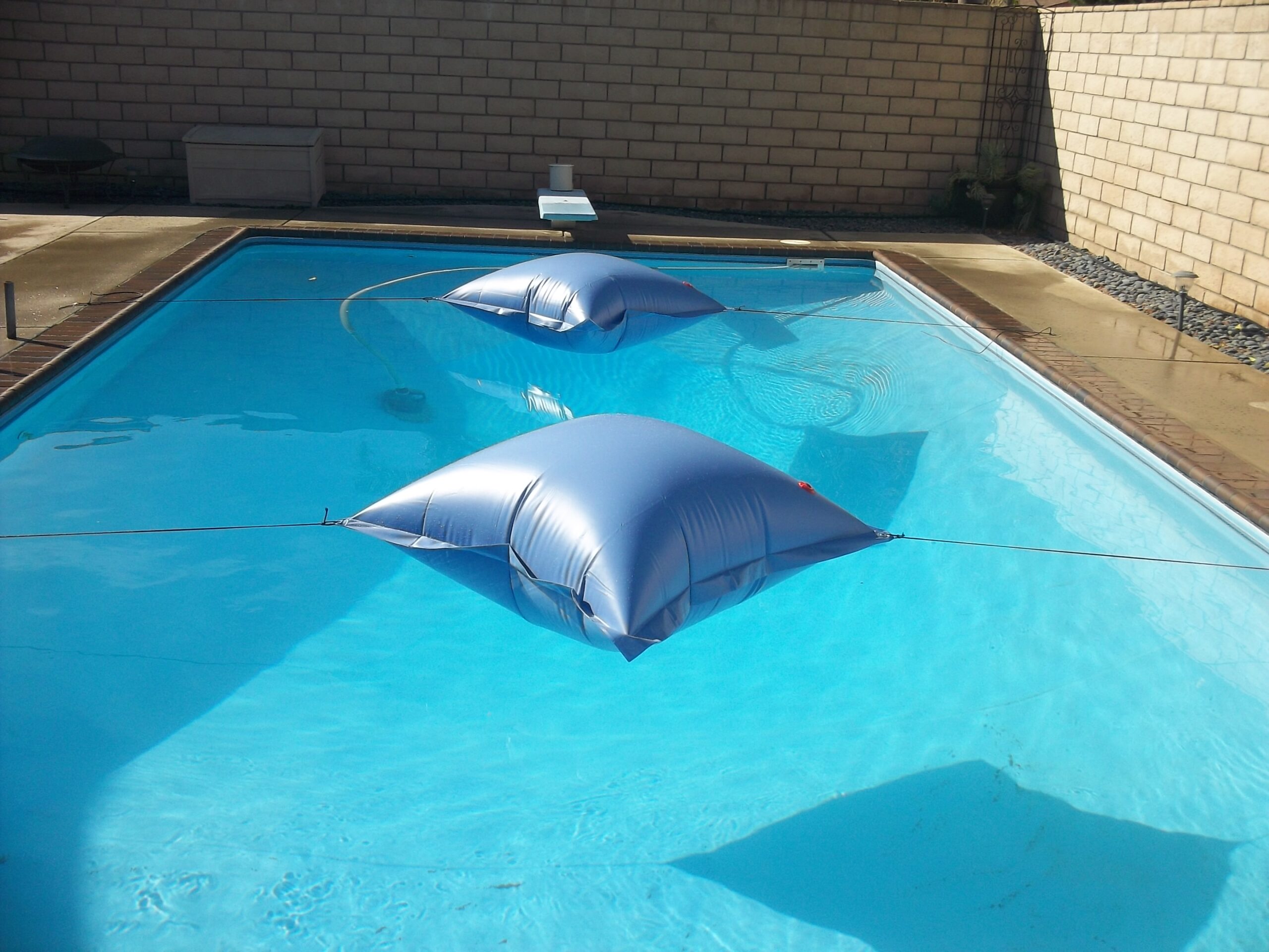 Air pillows secured over the pool before pulling the cover over the pool.