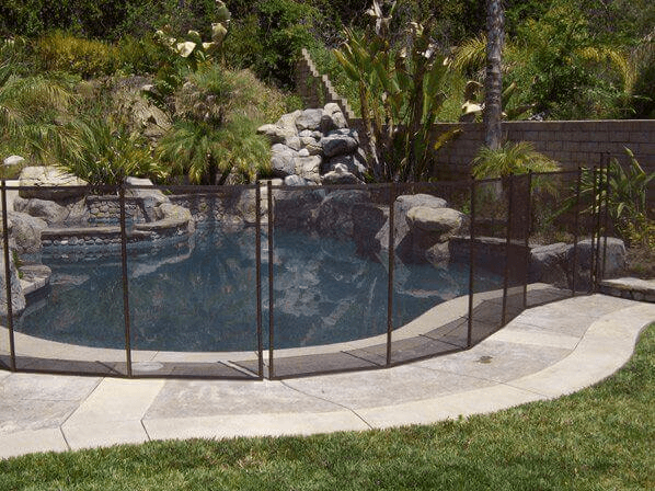 Brown mesh removable pool fencing installed around a backyard swimming pool