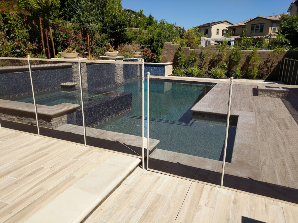 White mesh removable pool fencing installed on an irregular-shaped swimming pool