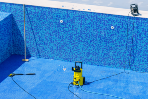 Empty swimming pool with cleaning tools sitting at the bottom