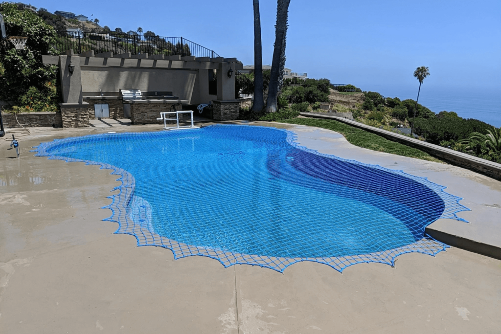 Blue swimming pool safety net installed over a swimming pool