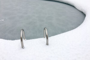 snow surrounding a frozen swimming pool