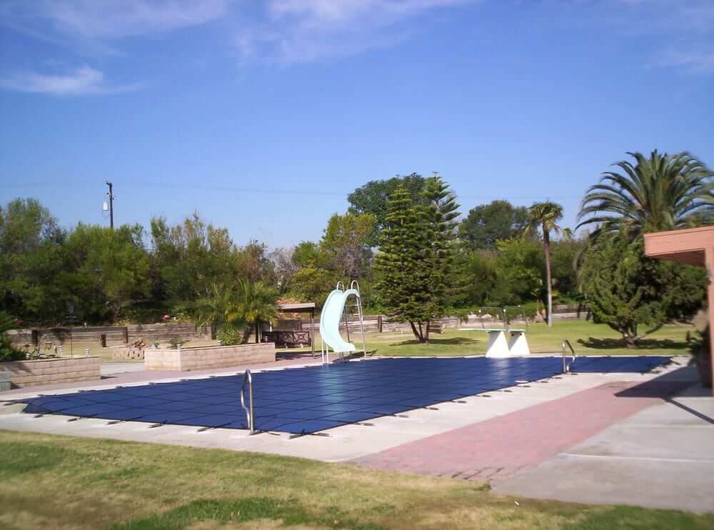 blue mesh winter pool cover installed on a swimming pool