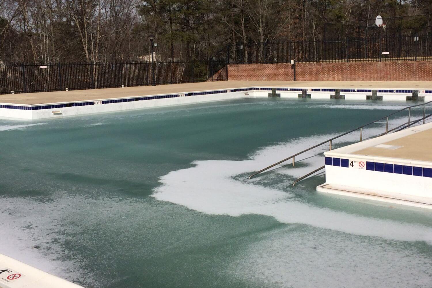 community swimming pool covered in a layer of ice after a winter storm