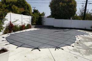 black winter pool cover installed over an irregular swimming pool