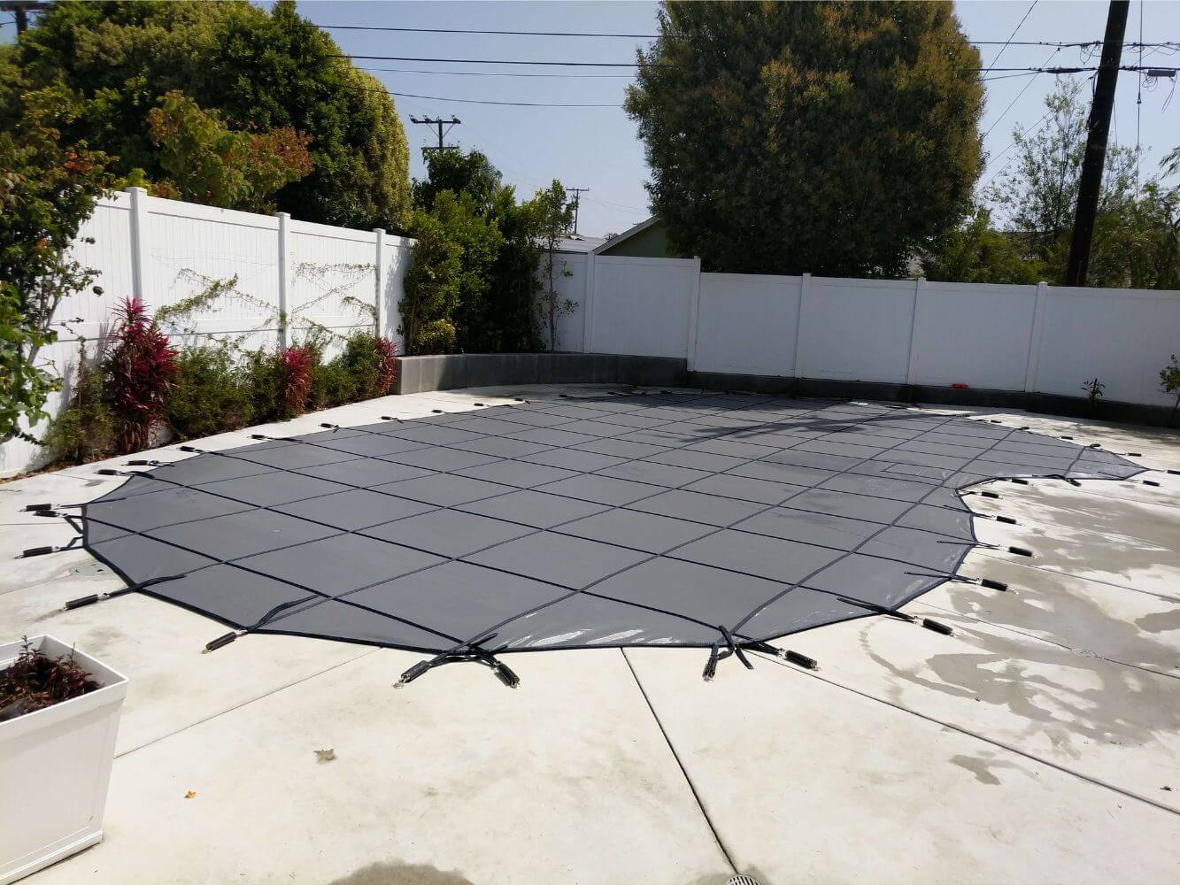 Black swimming pool cover installed on a residential pool