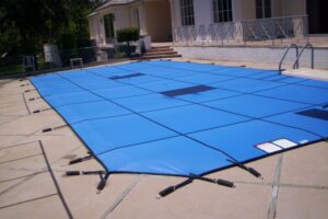 Blue winter pool safety cover secured on a small swimming pool