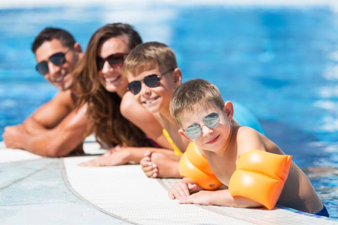 A family poses for a photo while in the swimming pool