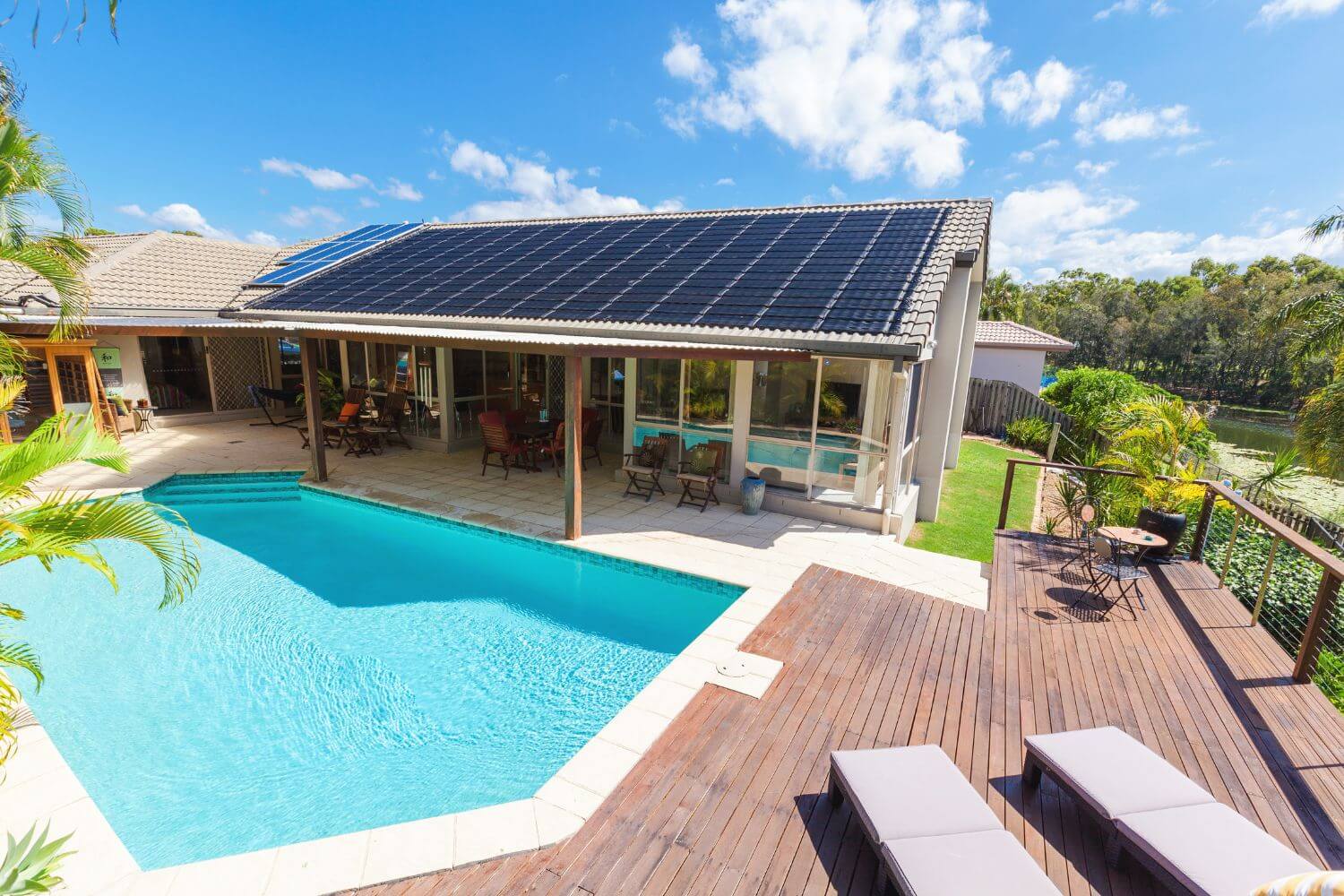 Wooden deck surrounding a backyard swimming pool with clear blue water