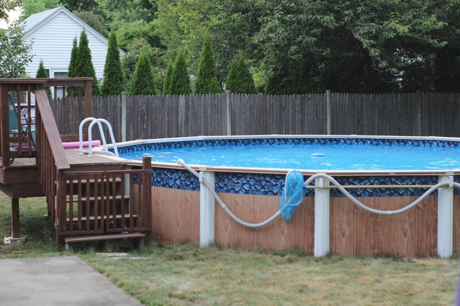 above ground pool with a small elevated wooden deck