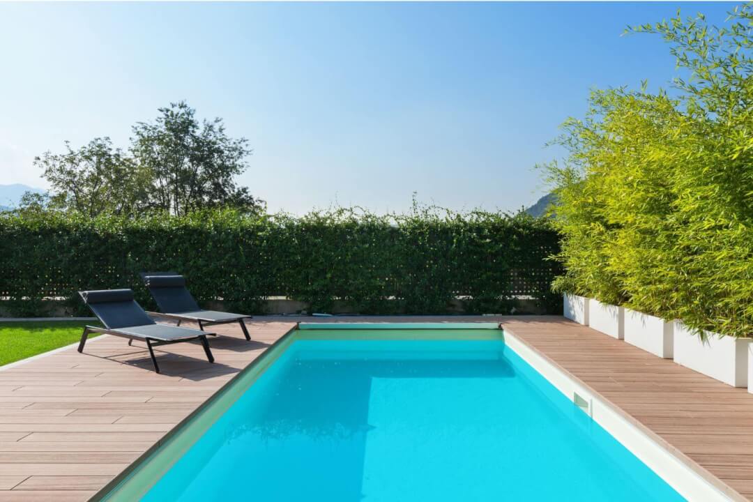 Rectangular backyard swimming pool surrounded by a wooden deck