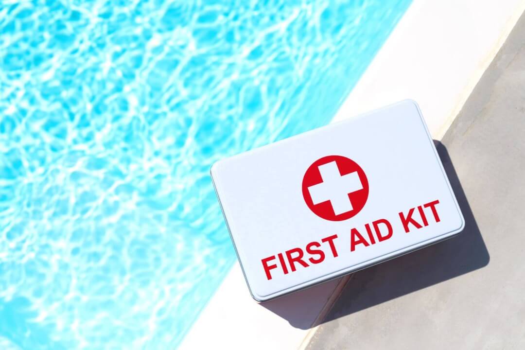 White first aid kit sitting next to a swimming pool