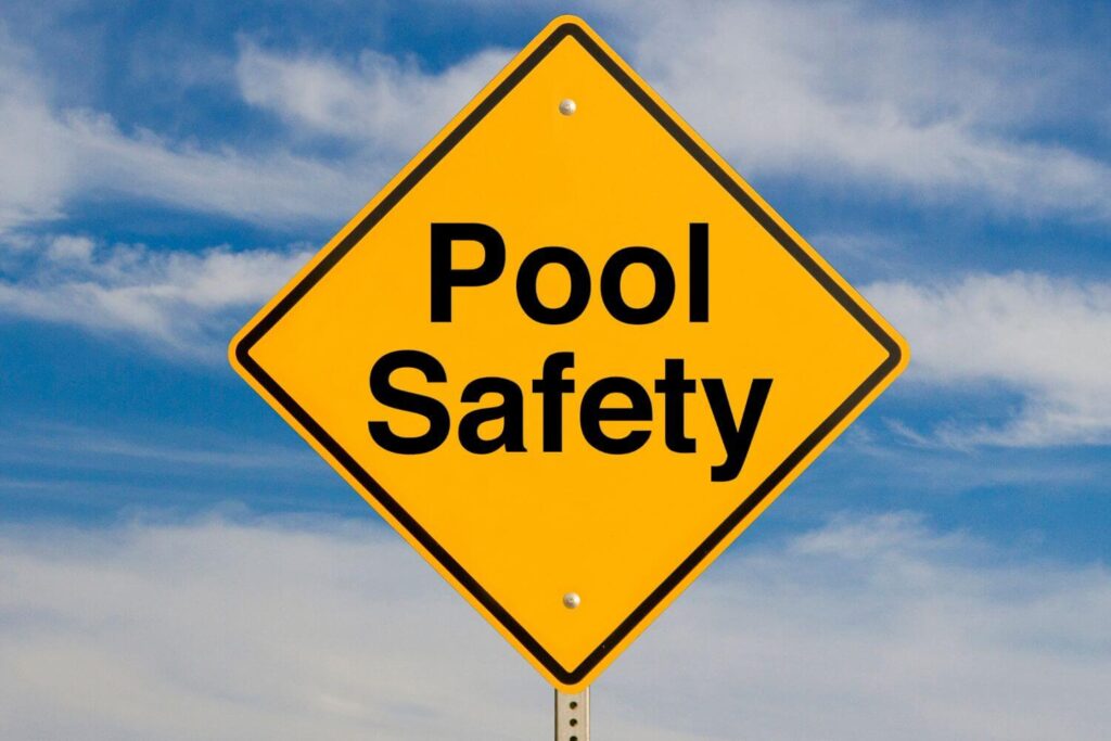 Yellow warning sign with black letters stating Pool Safety