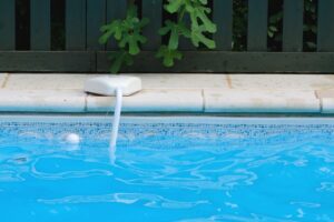 edge of a swimming pool with a white pool alarm installed