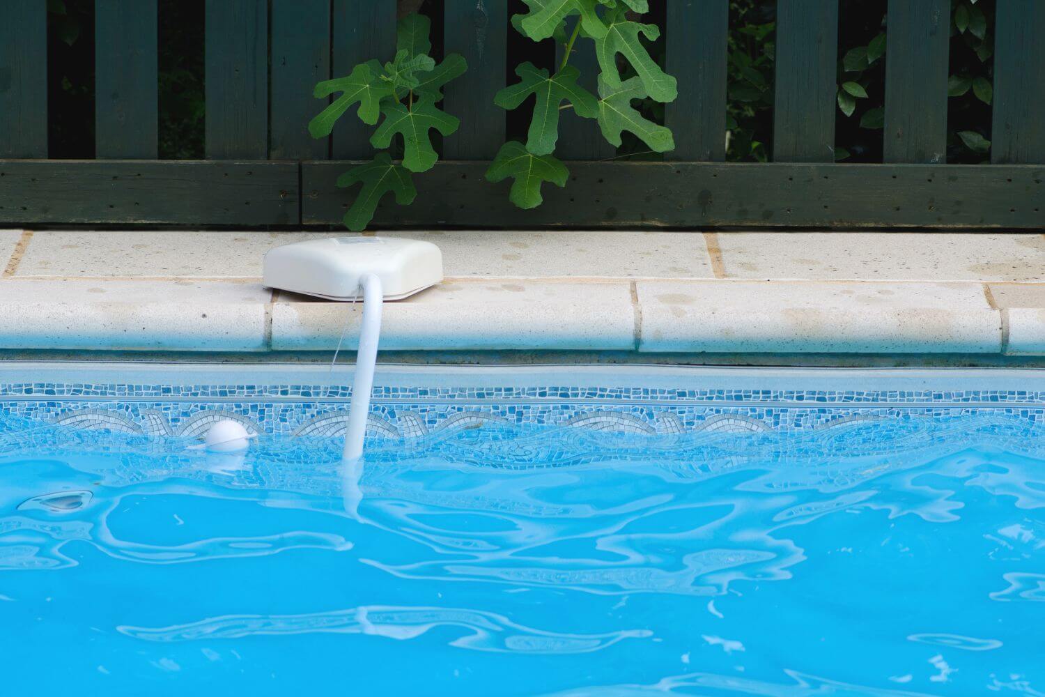 edge of a swimming pool with a white pool alarm installed