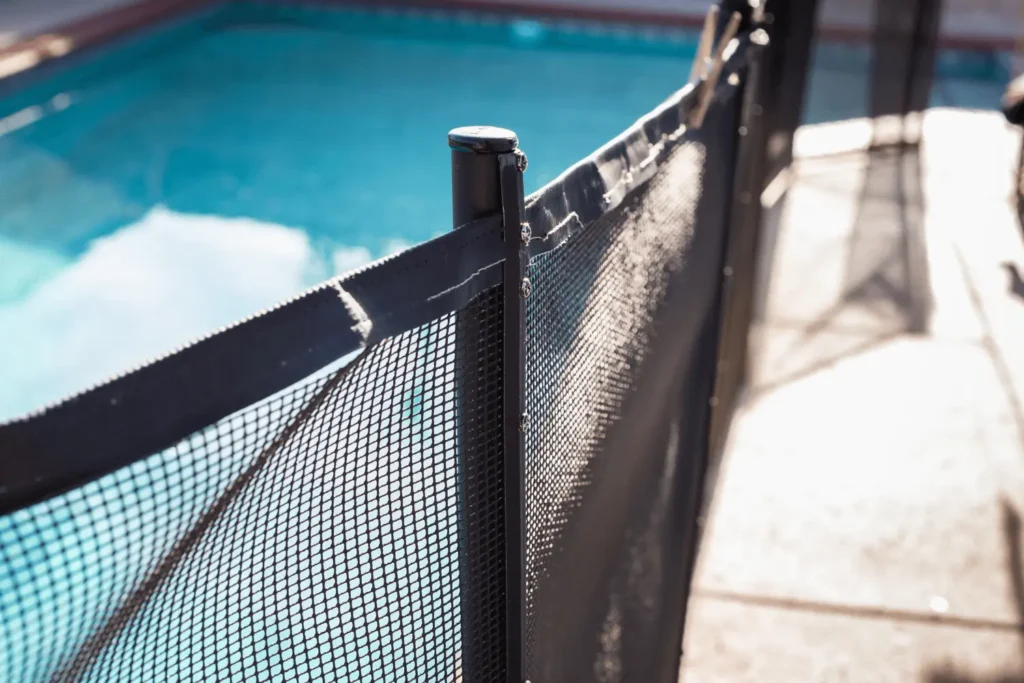 A close-up picture of a swimming pool safety fence polls and mesh tension