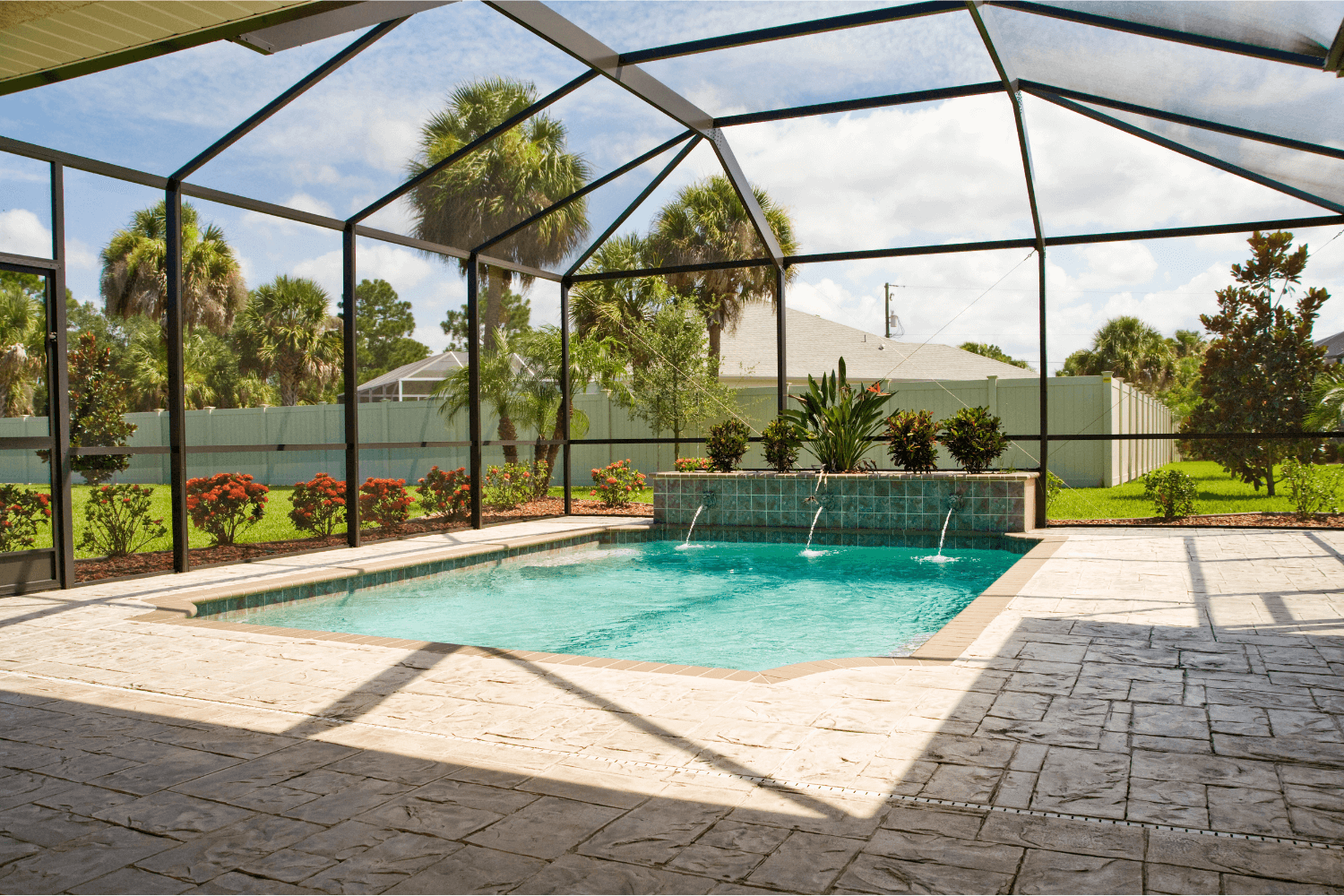 Backyard swimming pool with a screen enclosure around it