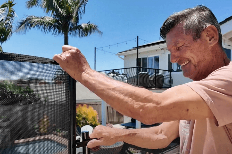Man installing a DIY Pool Fence in his backyard
