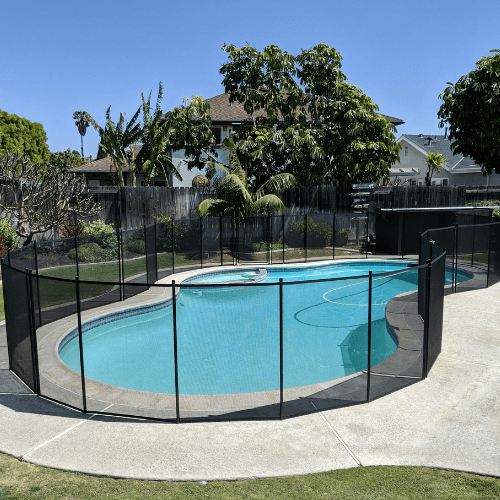 black mesh removable pool fence installed around an irregular shaped pool