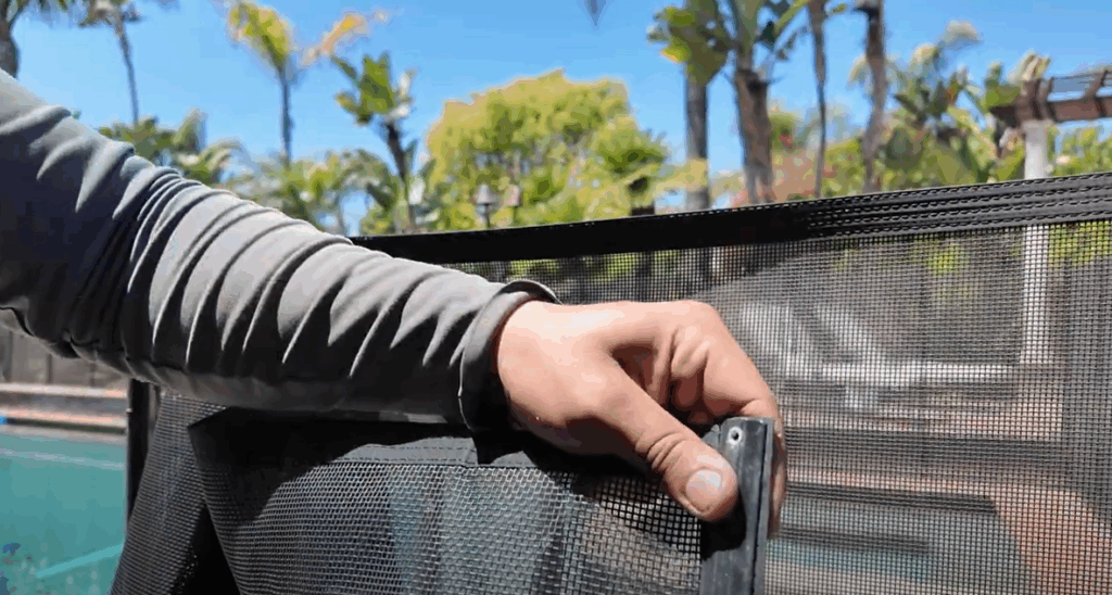 Hand holding molding and end of mesh panel.