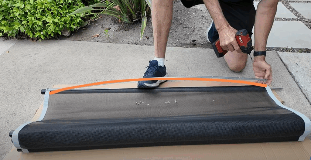 Installer using the foot method to stretch mesh.