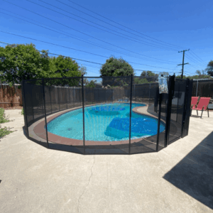 black mesh pool fence surrounding an irregular shaped pool