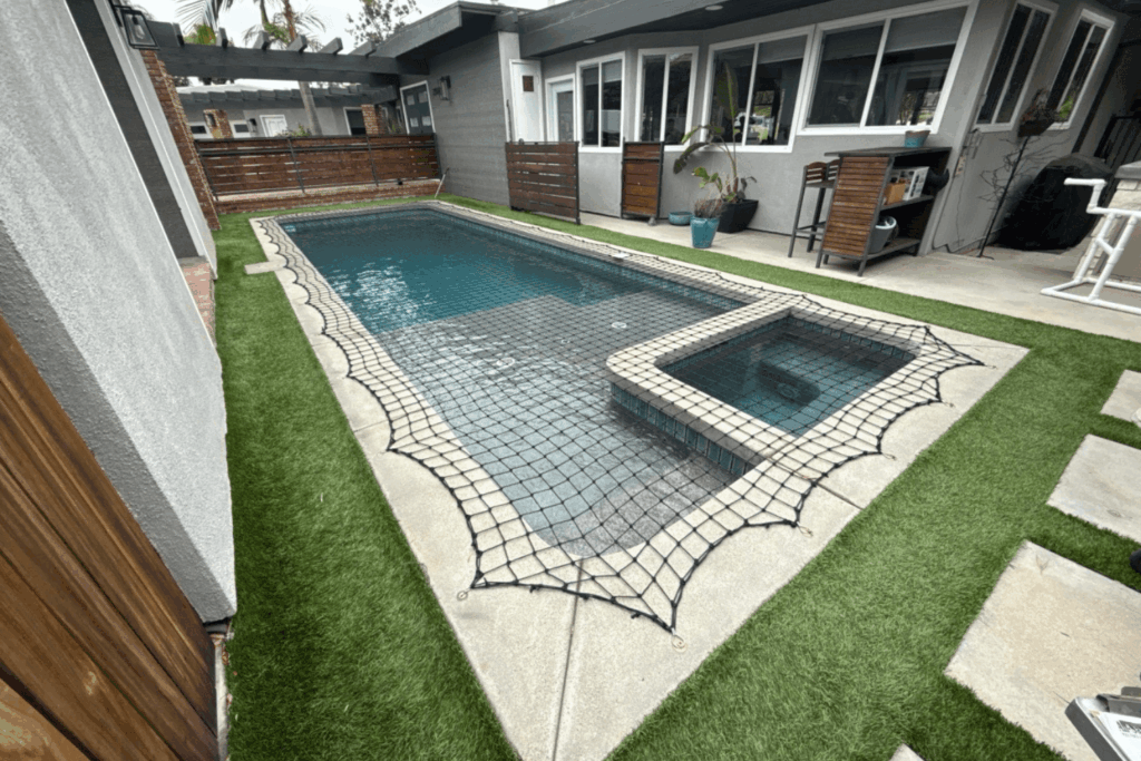 black pool safety net installed around a small rectangular pool and spa
