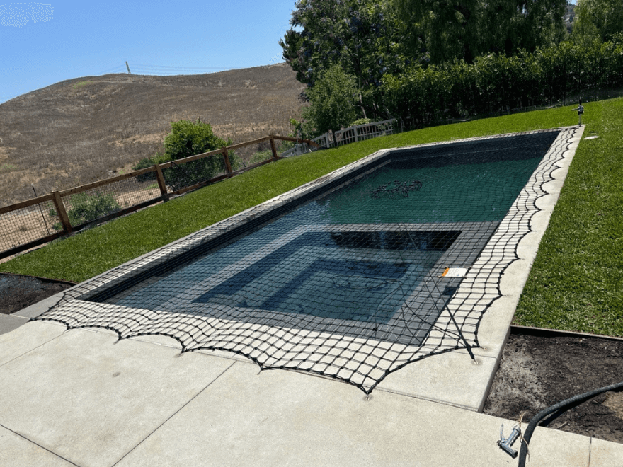 black pool safety net installed around a small rectangular swimming pool