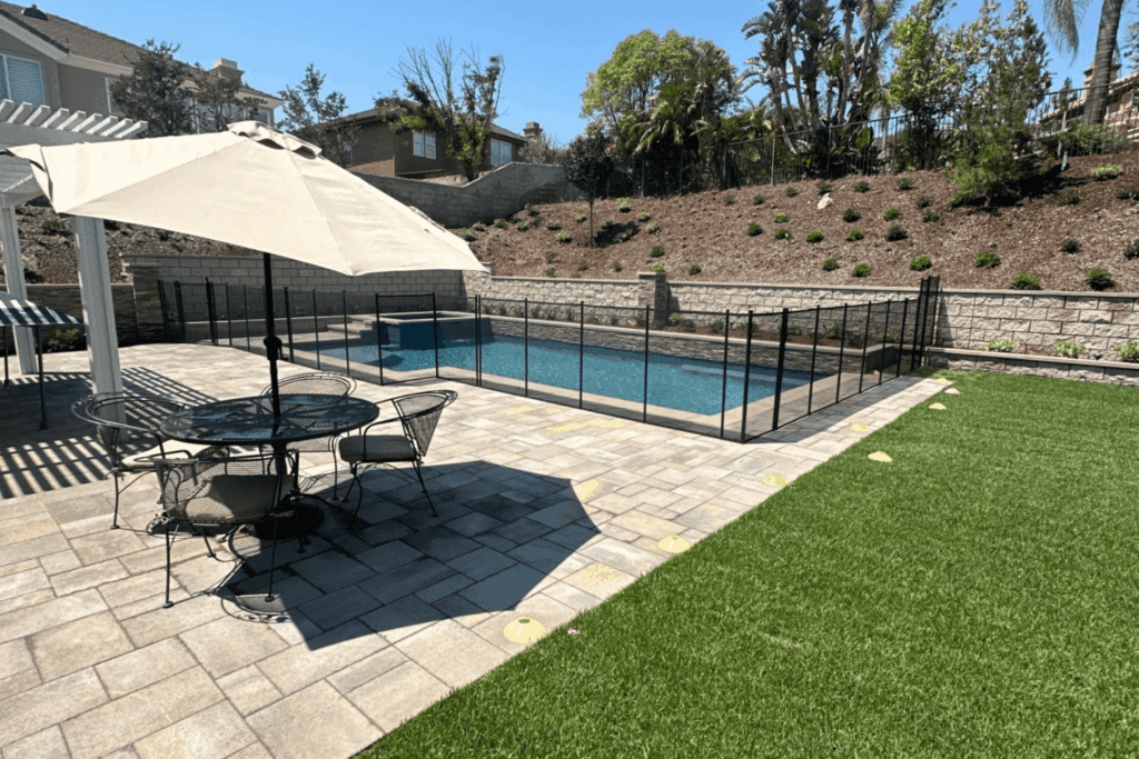 black removable mesh pool fence installed around a swimming pool for pet safety