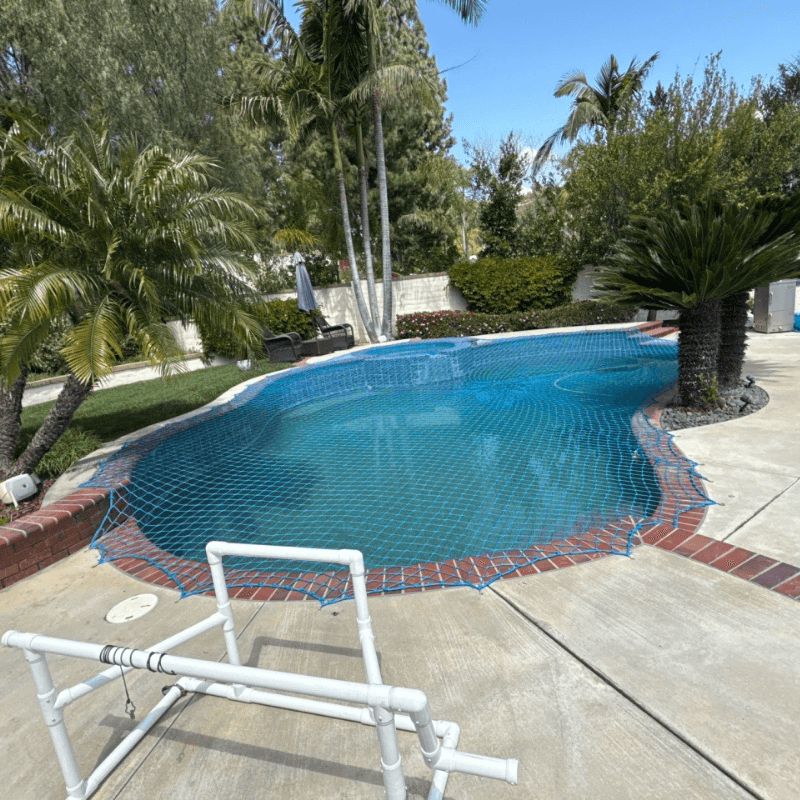blue pool safety net installed over a swimming pool