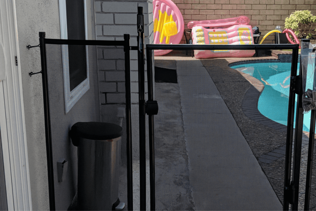 A backyard pool safety fence in black mesh material