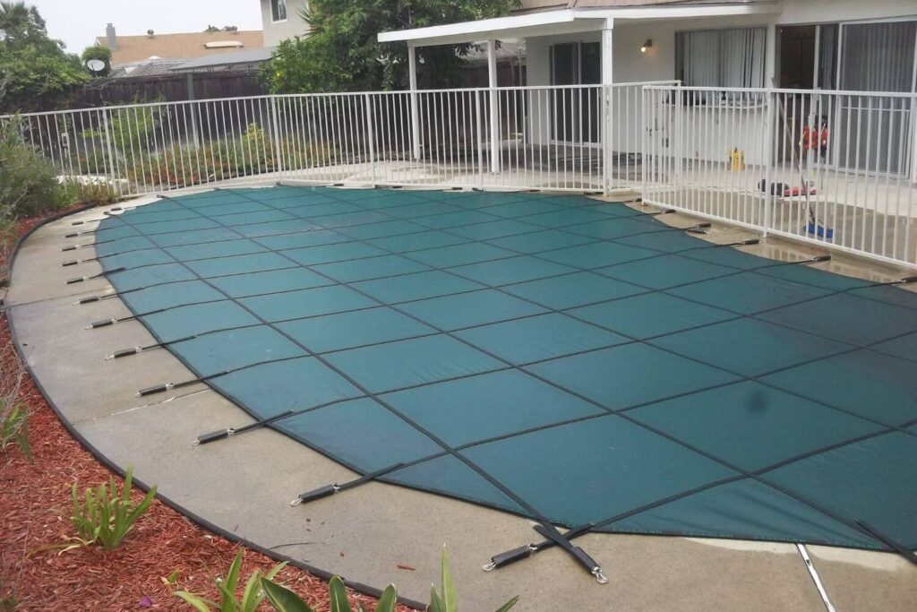 green mesh winter safety cover installed over a swimming pool