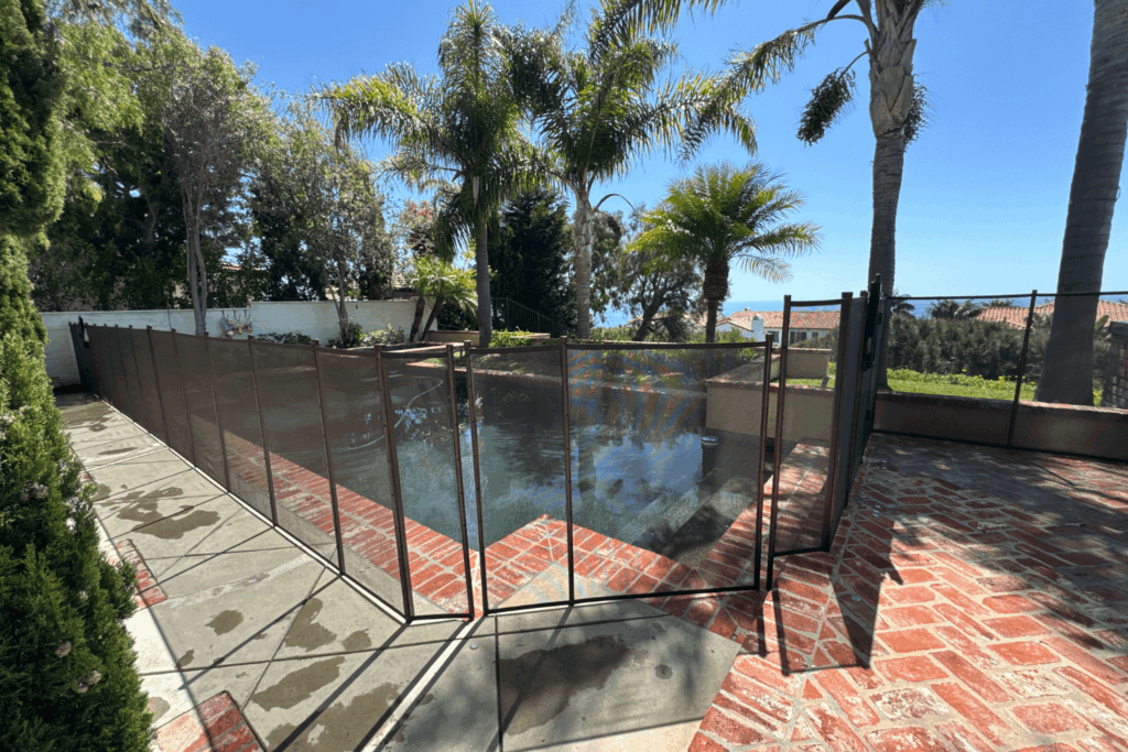 brown mesh pool fence installed around a pool