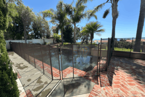 brown mesh pool fence installed around a pool